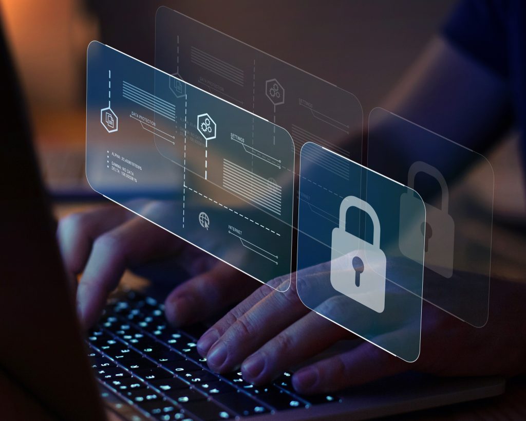 Someone typing on a computer with a screen showing a lock, settings, and data protection.